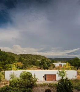 A modern residential house with white stucco exterior and glass windows.