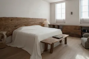 A minimalist bedroom featuring a wooden bed with a textured wooden headboard and a matching wooden bench.