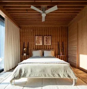 Minimalist bedroom featuring a bed with white bedding and a wood-paneled wall