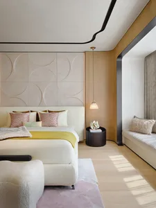 A modern bedroom featuring a bed with a textured bedspread and a wooden headboard.
