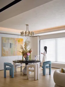 Modern dining room with elegant furniture and a chandelier.