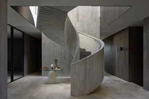 Interior view of a modern industrial staircase with concrete walls and floor.