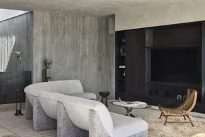 A modern living room with a concrete wall and floor.