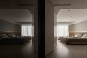 A minimalist bedroom with neutral tones, white curtains, and a simple bed.