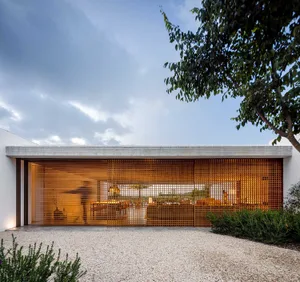 A modern residential exterior with a concrete facade and wooden lattice panels.