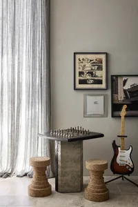 A minimalist game room with a stone table and cork stools.