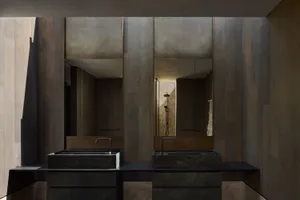 A modern bathroom with concrete sinks and mirrors.