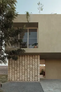 Modern house exterior with textured concrete facade and large windows