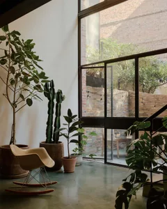A modern industrial living space featuring concrete elements and large windows.