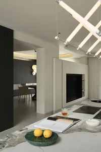 Modern kitchen with marble countertops, a built-in fireplace, and contemporary lighting fixtures.