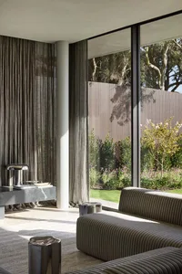 Modern living room featuring textured glass, metal accents, and fabric seating.