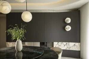 A modern kitchen with marble countertops and cabinets.