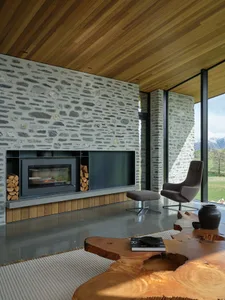 Minimalist living room featuring contemporary design elements and natural materials such as wood, concrete, and stone.