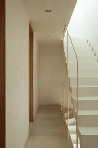 Modern minimalist concrete staircase with metal railings, viewed from a side angle.