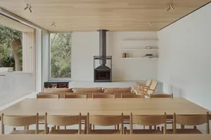 Minimalist residential interior featuring wood elements and a large floor-to-ceiling window.