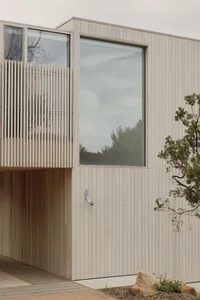 A modern house with a wooden exterior and large windows.