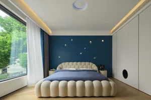 A modern bedroom featuring a textured fabric bed with blue walls and floating lights on the ceiling.