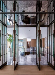 Modern interior design of an entryway featuring marble flooring and walls.
