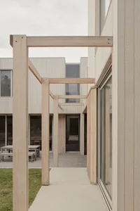 A modern building exterior with light-colored wooden beams and large glass windows.
