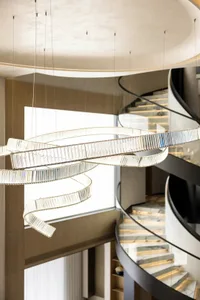 Modern interior design featuring a glass staircase with a spiral design.