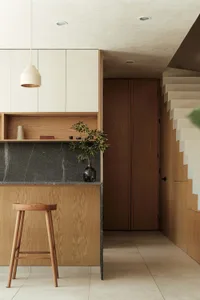 Modern kitchen featuring wooden furniture and marble countertop.