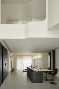 A modern minimalist kitchen featuring concrete and glass materials.