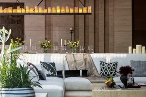 A modern living room featuring luxurious candles, stylish decorations, and comfortable seating arrangements.