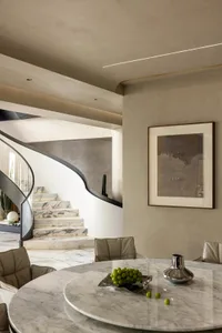 Modern interior with marble dining table, chairs, and abstract art painting.