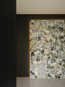 A modern minimalist interior with a marble wall illuminated by ambient lighting.