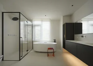 A modern residential bathroom featuring a glass shower enclosure, a freestanding bathtub, and sleek black cabinetry with unde