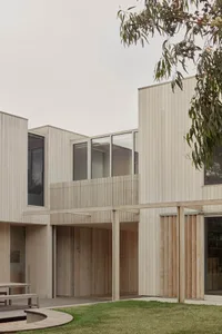 Modern residential building with wooden exterior and large windows.