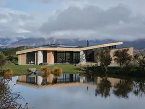 A modern house with a wooden exterior situated in a rural area.