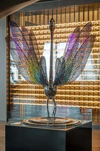 A large, metallic dragonfly sculpture with multicolored wings on display.