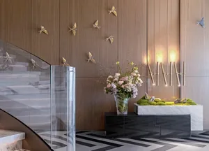 Modern lobby interior with glass, wood paneling, and marble accents.
