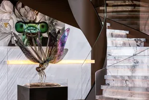 A modern staircase featuring glass, metal, and marble materials.