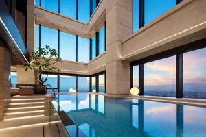 Modern interior design featuring a glass-walled swimming pool with a serene view.