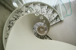 Circular staircase made of white and black marble materials.