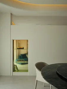 Modern minimalist living room featuring a glass shelf with books and decorative items.