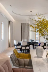 Modern dining room with marble table and chairs, featuring elegant chandeliers