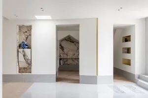 A modern interior featuring marble and concrete elements in an entryway setting.