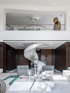 A modern living room with a marble table, wooden floors, and metal accents.