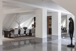 A modern residential interior featuring concrete, wood, and marble finishes.