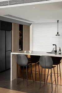 A modern kitchen with a marble countertop and black wood accents, featuring minimalist design and sleek finishes.