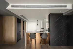 Modern kitchen interior featuring marble countertops and blackwood cabinets.