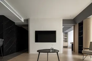 A modern living room with minimalist furniture and floor tiles.