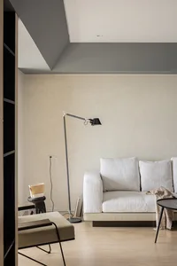 Modern minimalist living room with textured furniture, clean lines, and neutral color palette.
