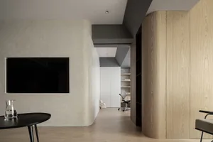 A minimalist office space featuring wood-paneled walls and a simple, sleek design.