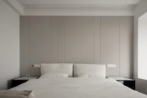 A minimalist bedroom features textured wall panels, a bed with white sheets, and two nightstands.