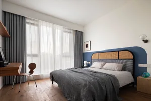 A modern bedroom featuring wooden furniture and fabric bedding.