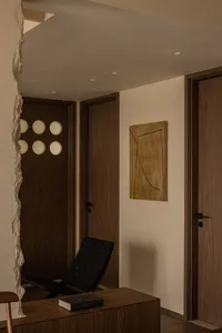 A modern entrance hall featuring wooden paneling and a geometric light fixture.